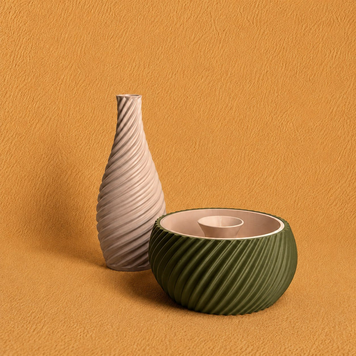 Shell & Seed and Spiral Vase bundle featuring an olive green ribbed Shell & Seed piece with an ivory interior alongside an ivory spiral-textured vase on a warm textured background.