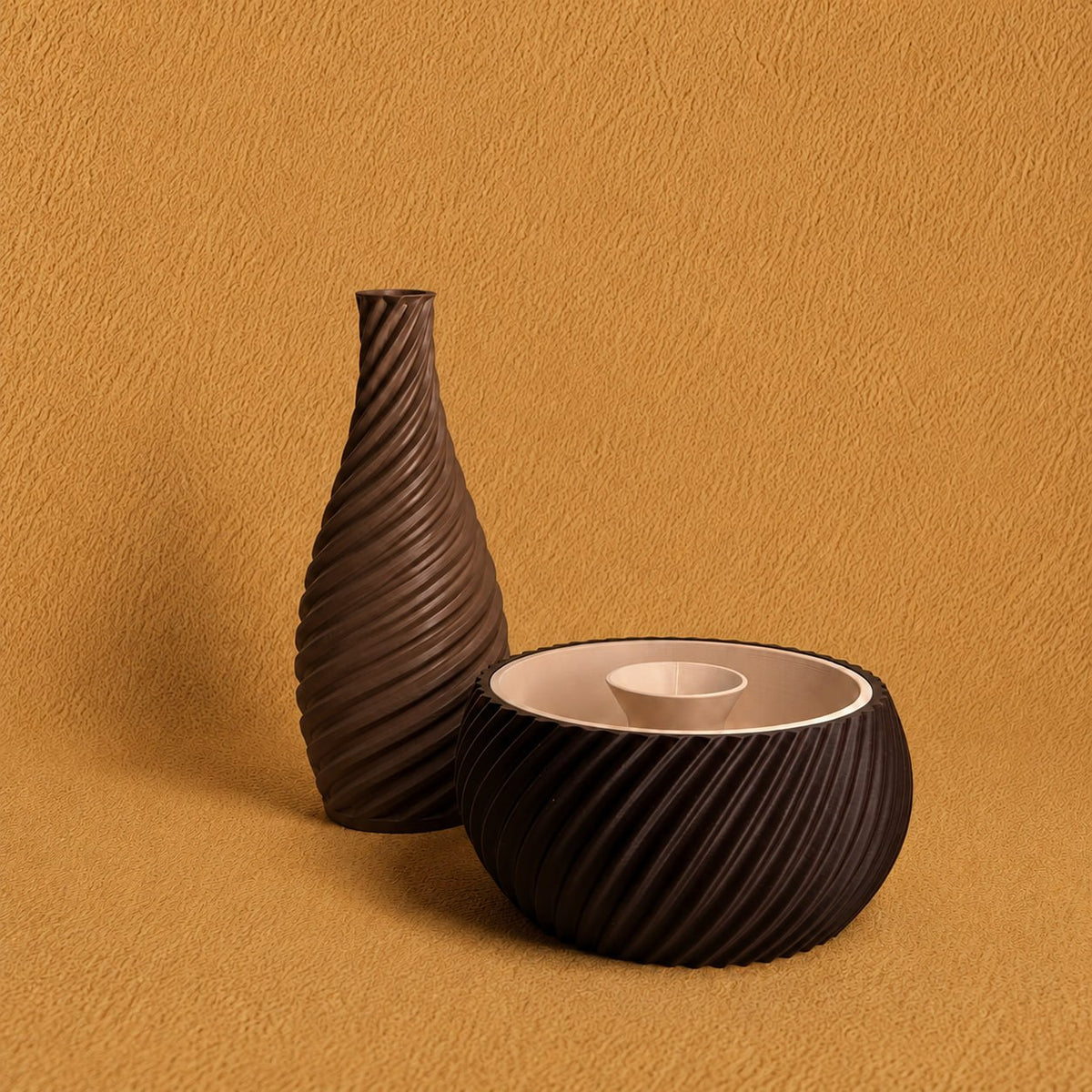 Shell & Seed and Spiral Vase bundle featuring an brown ribbed Shell & Seed piece with an ivory interior alongside an brown spiral-textured vase on a warm textured background.