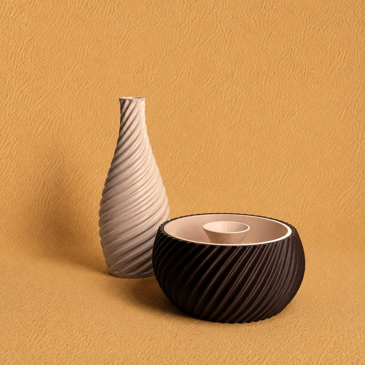 Shell & Seed and Spiral Vase bundle featuring an brown ribbed Shell & Seed piece with an ivory interior alongside an ivory spiral-textured vase on a warm textured background.