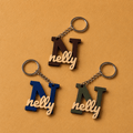 Customized initial keychain medals featuring a personalized letter and name design, attached to a metal key ring.
