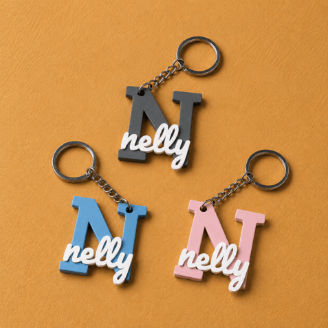 Customized initial keychain medals featuring a personalized letter and name design, attached to a metal key ring.
