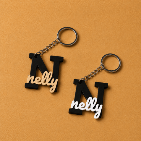 Customized initial keychain medals featuring a personalized letter and name design, attached to a metal key ring.
